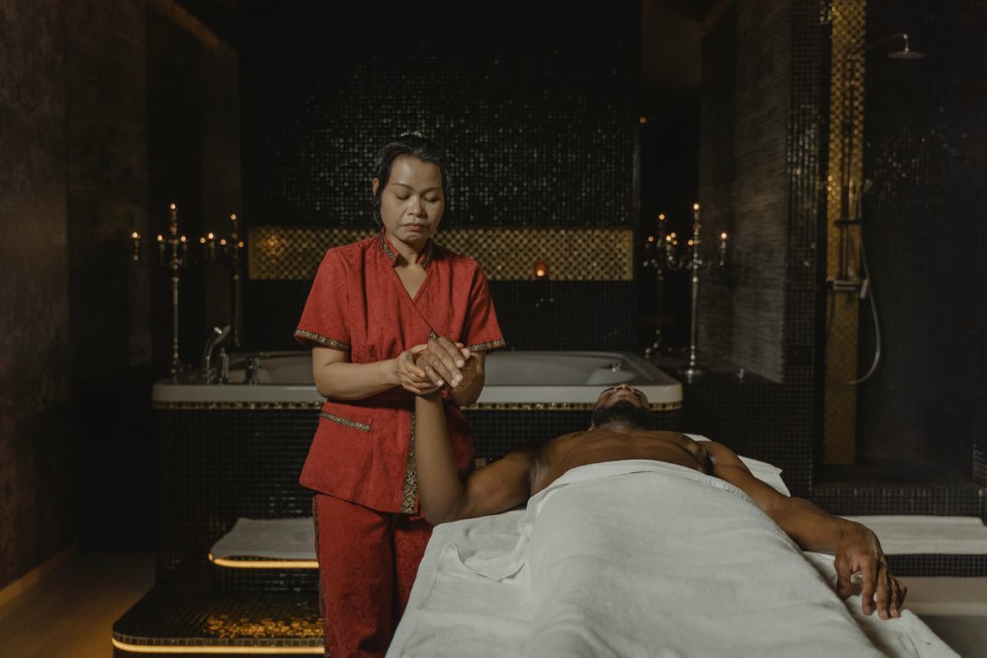 Warm candlelit treatment room at Gulsan Spa with a therapist preparing a massage