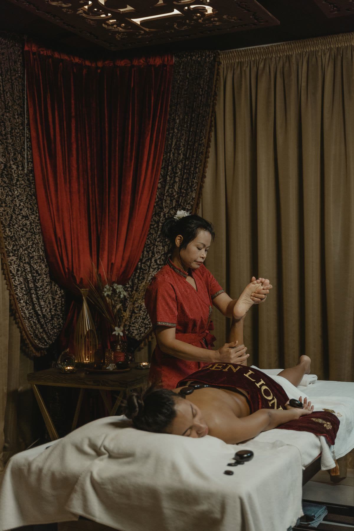 Elegant red curtained massage room with a therapist treating a client at Gulsan Spa