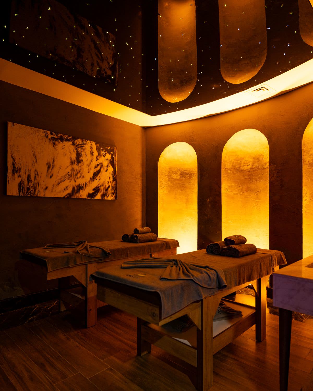 Warm golden lit luxury spa interior with massage beds