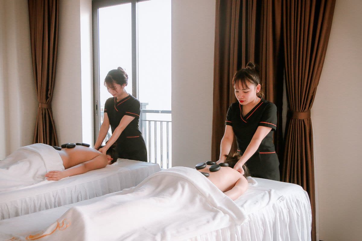 Two therapists treating clients side by side in a luxury spa room
