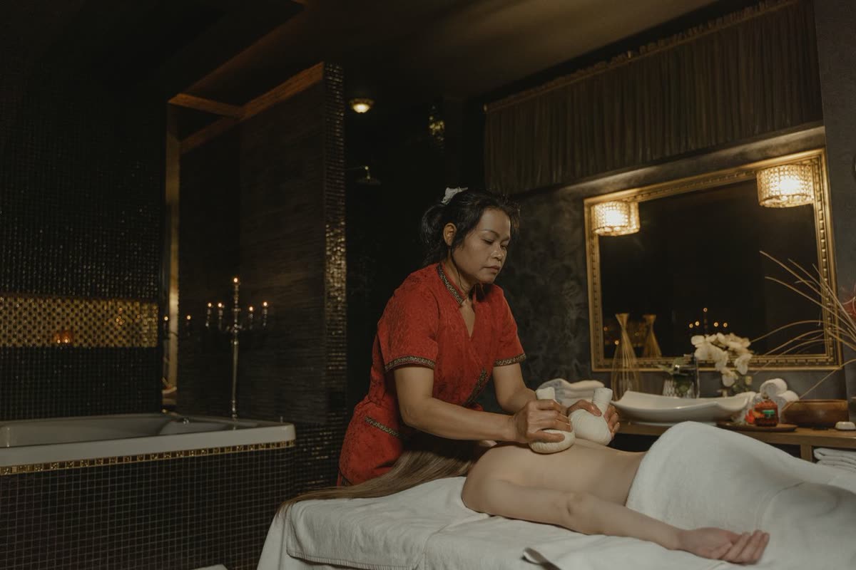 Professional massage therapy session in a warm candlelit spa room