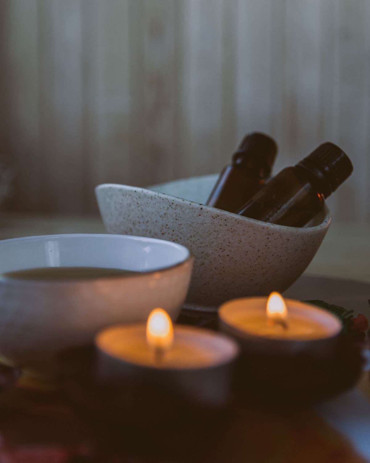 Aromatherapy oils, mortar and warm candles arranged in a luxury spa room