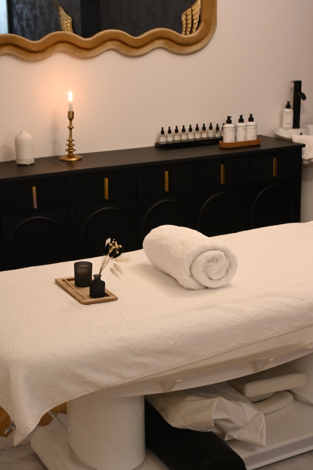 Elegant spa massage table with rolled towel and scented candle