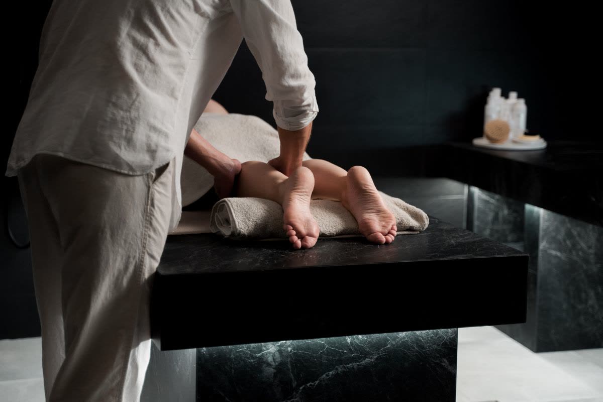 Relaxing foot reflexology massage in a dimly lit luxury spa room
