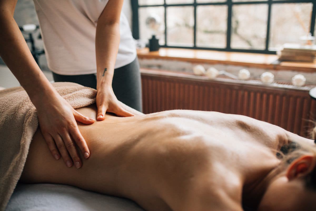 Warm oil massage being performed on a client in a candlelit spa room at Gulsan Spa